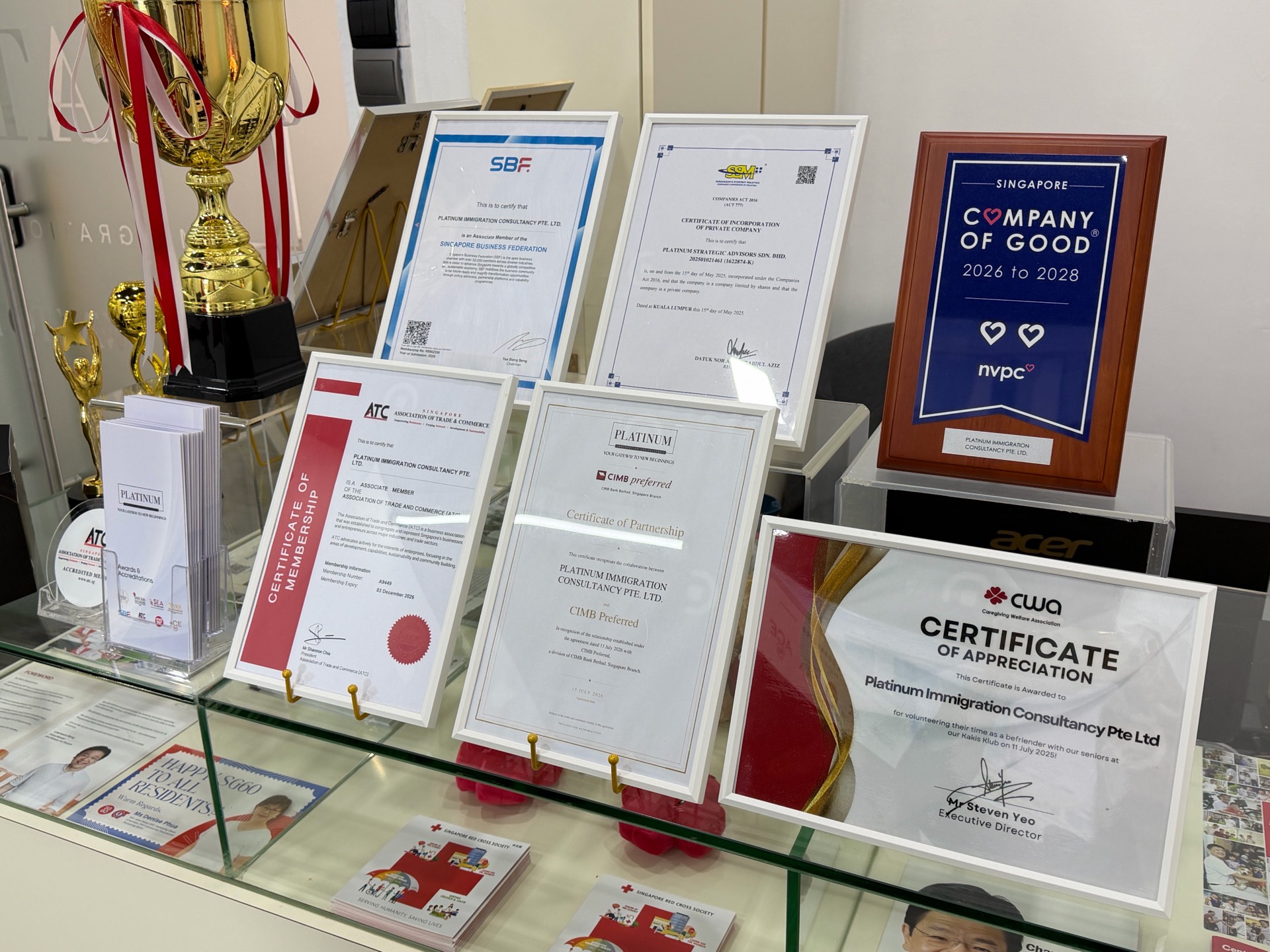 Membership certificates at Platinum Immigration Consultancy, including the Singapore Business Federation and the NVPC Company of Good plaque
